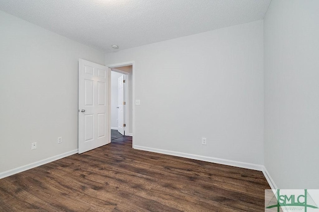 unfurnished room with dark hardwood / wood-style floors and a textured ceiling