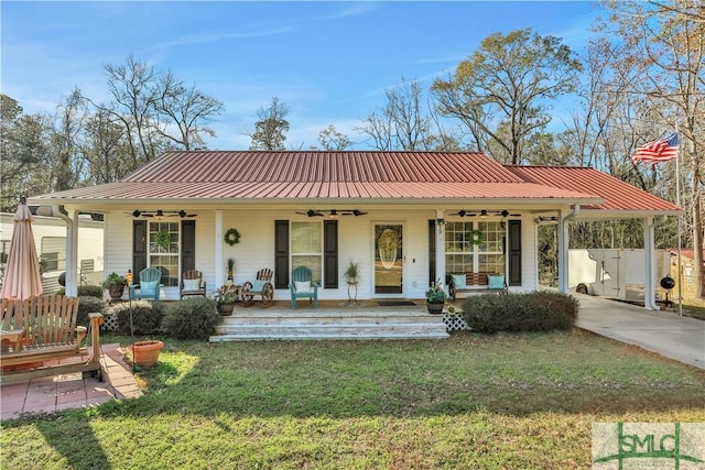 view of front of home featuring a front yard, a carport, ceiling fan, and covered porch