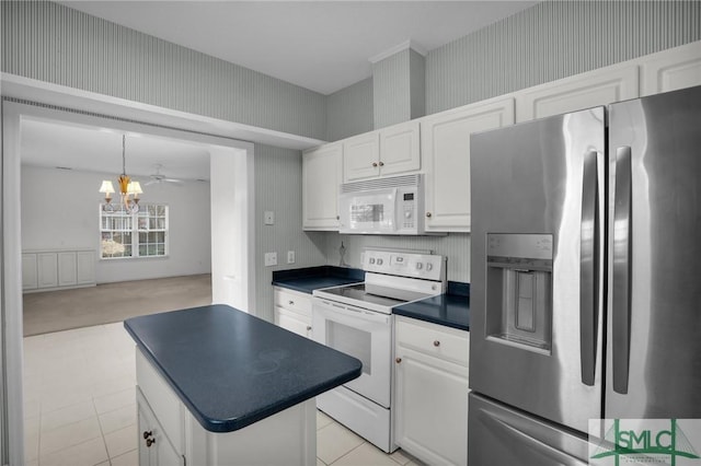 kitchen with a notable chandelier, white cabinets, and white appliances