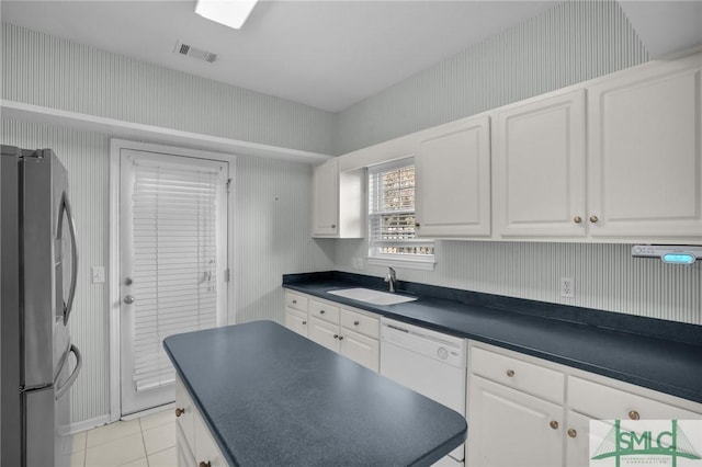 kitchen featuring stainless steel fridge, dishwasher, sink, and white cabinets