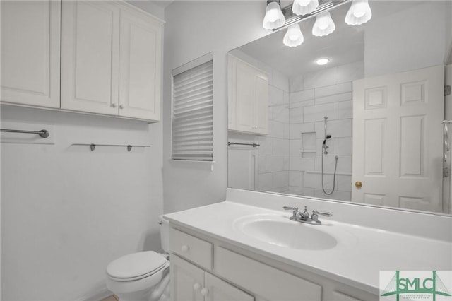 bathroom featuring a shower, vanity, and toilet