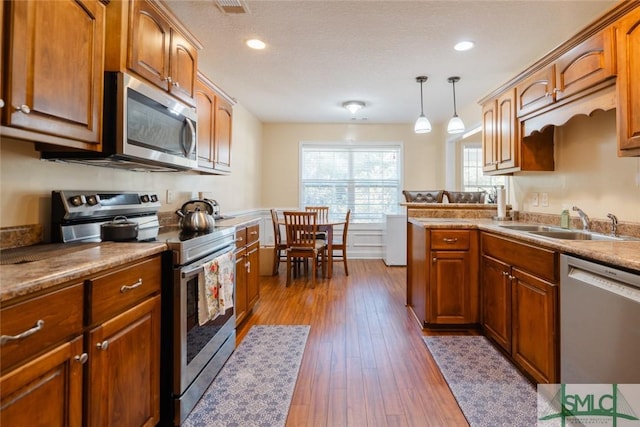 164 Glynn Ct, Hinesville, GA 31313 - kitchen with sink, hardwood / wood-style flooring, appliances with stainless steel finishes, a textured ceiling, and decorative light fixtures
