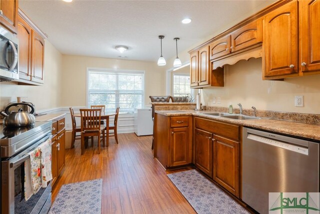 164 Glynn Ct, Hinesville, GA 31313 - kitchen with pendant lighting, sink, kitchen peninsula, stainless steel appliances, and light wood-type flooring