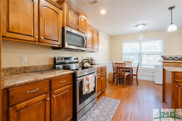 164 Glynn Ct, Hinesville, GA 31313 - kitchen with pendant lighting, light hardwood / wood-style floors, a textured ceiling, and appliances with stainless steel finishes