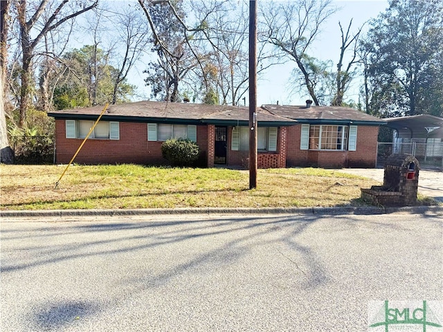 ranch-style house featuring a carport and a front yard