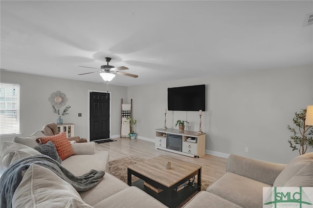 living room with ceiling fan and light hardwood / wood-style flooring