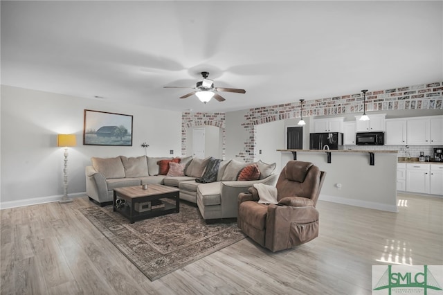 living room featuring ceiling fan and light hardwood / wood-style flooring