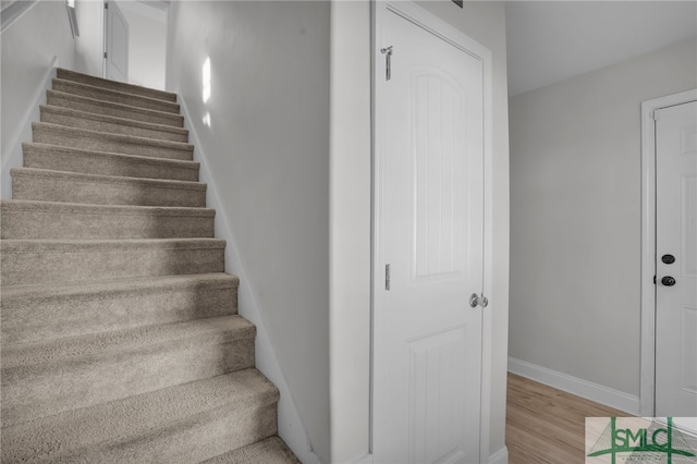 stairway with hardwood / wood-style flooring