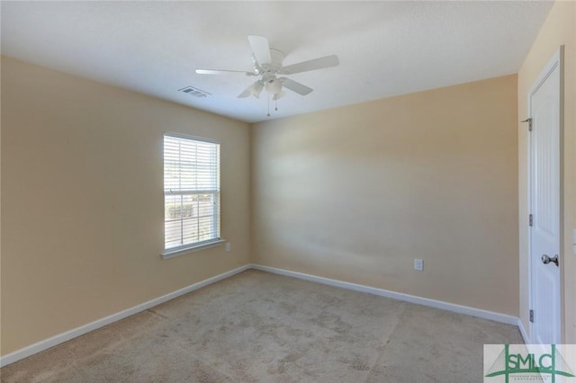 spare room with ceiling fan and light colored carpet