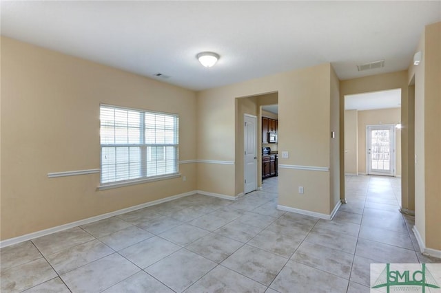 tiled spare room with plenty of natural light