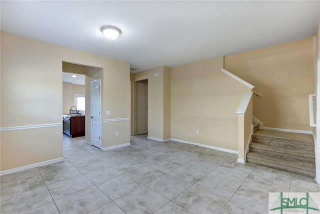 spare room featuring sink and light tile patterned flooring