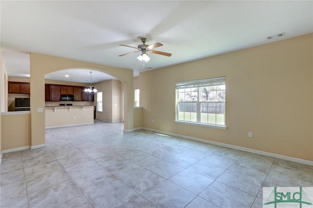 unfurnished living room featuring light tile patterned flooring and ceiling fan with notable chandelier