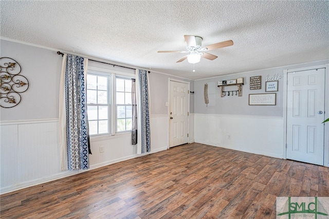 entrance foyer featuring ceiling fan, a textured ceiling, and dark hardwood / wood-style flooring