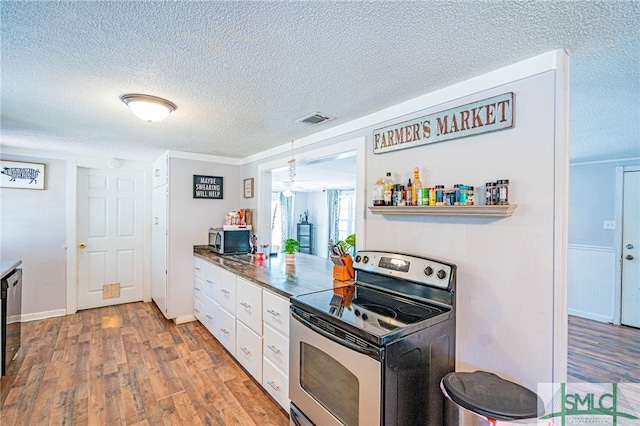 kitchen with a textured ceiling, light hardwood / wood-style flooring, pendant lighting, stainless steel appliances, and white cabinets