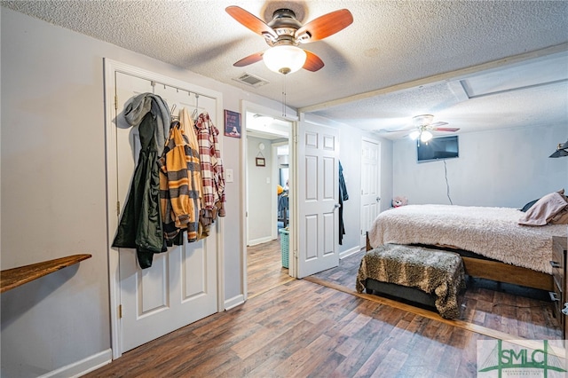 bedroom with ceiling fan, wood-type flooring, a closet, and a textured ceiling