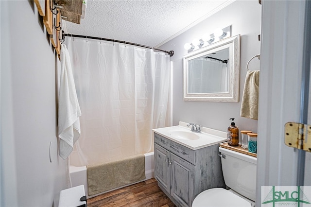 full bathroom with hardwood / wood-style flooring, shower / tub combo, vanity, a textured ceiling, and toilet