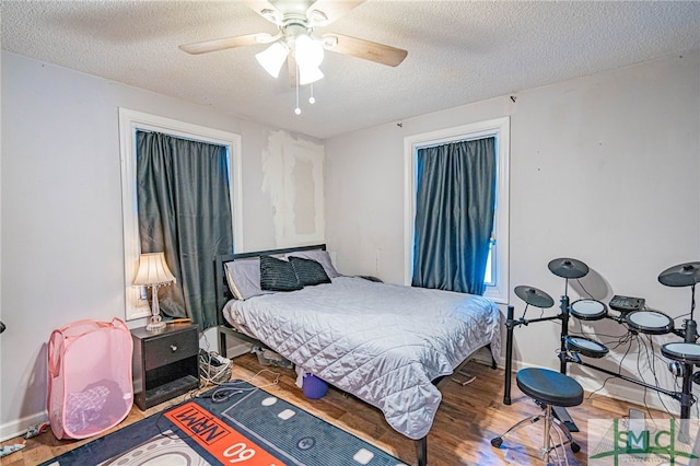 bedroom featuring ceiling fan, wood-type flooring, and a textured ceiling