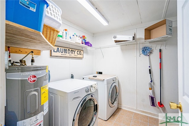 laundry room with light tile patterned floors, washing machine and dryer, and electric water heater