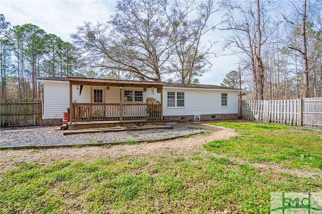 back of house featuring a lawn and a deck