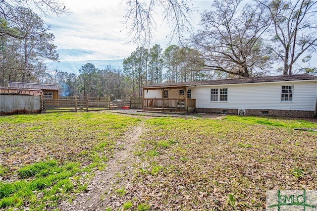 rear view of house featuring a yard and a deck