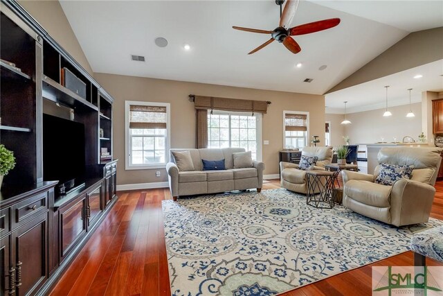 living room featuring dark wood-type flooring, ceiling fan, and vaulted ceiling