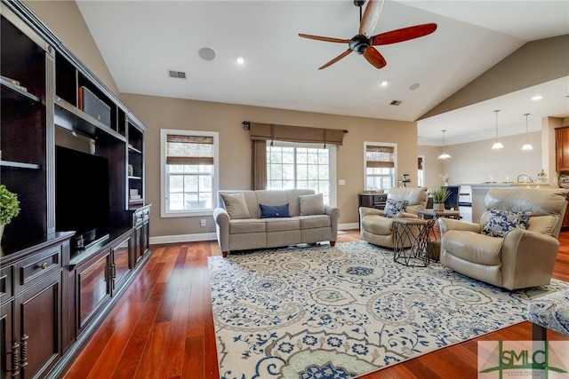 living room featuring lofted ceiling, dark wood finished floors, visible vents, and baseboards