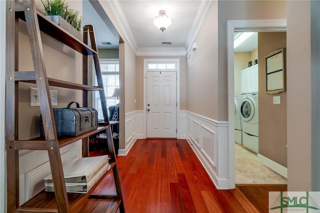 entryway featuring crown molding, wood-type flooring, and washing machine and clothes dryer