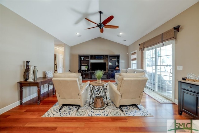 living room with wood-type flooring, lofted ceiling, and ceiling fan