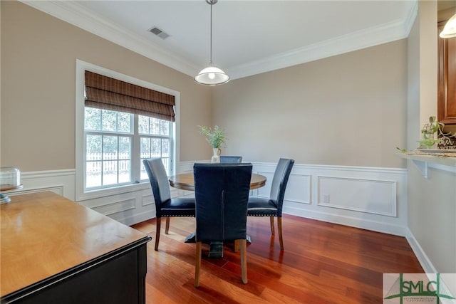 dining area featuring hardwood / wood-style flooring and crown molding