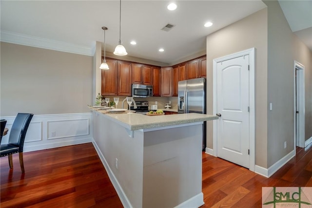 kitchen with a breakfast bar area, hanging light fixtures, dark hardwood / wood-style flooring, kitchen peninsula, and stainless steel appliances