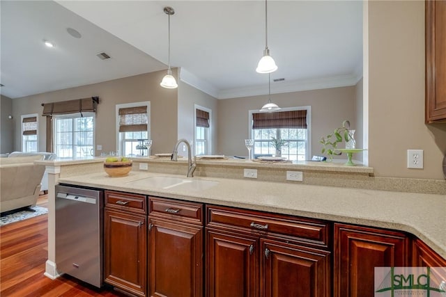 kitchen featuring pendant lighting, dishwasher, sink, light stone counters, and plenty of natural light