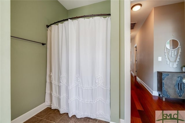 bathroom with tile patterned flooring and curtained shower