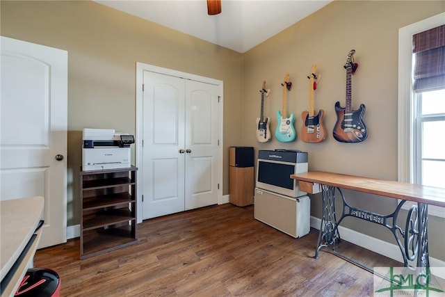 office area with dark wood-style floors, ceiling fan, and baseboards