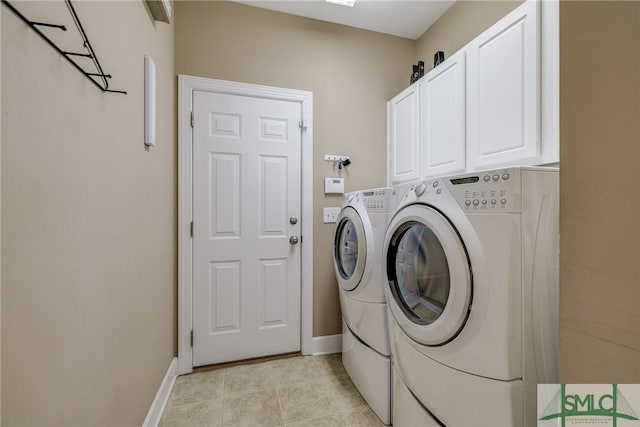 washroom featuring light tile patterned floors, cabinets, and washing machine and clothes dryer