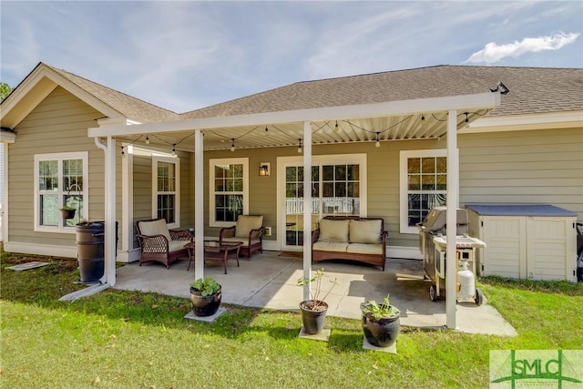 rear view of house featuring roof with shingles, a patio, an outdoor living space, and a lawn