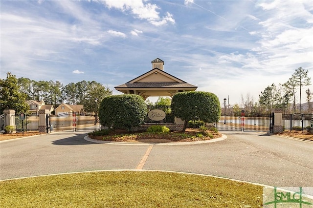 view of street with a gate, curbs, and a gated entry