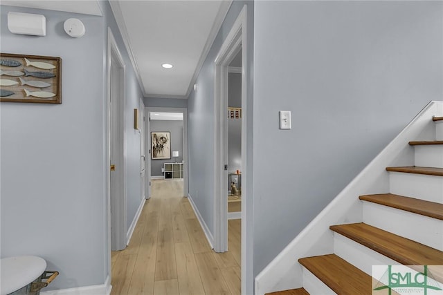 hallway featuring ornamental molding and light hardwood / wood-style floors