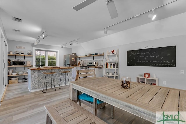 dining area with rail lighting, ceiling fan, and light wood-type flooring