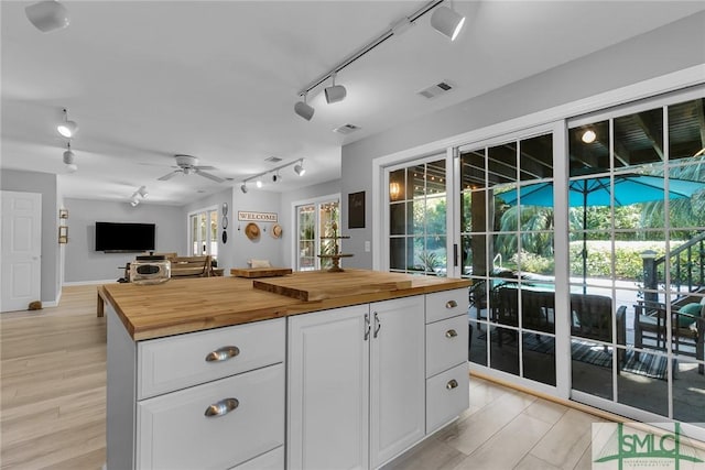 kitchen featuring white cabinetry, track lighting, wooden counters, and light hardwood / wood-style floors