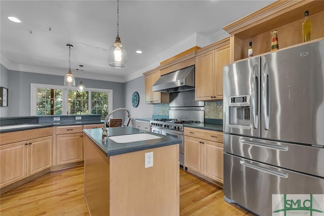 kitchen featuring wall chimney exhaust hood, ornamental molding, appliances with stainless steel finishes, pendant lighting, and a kitchen island with sink