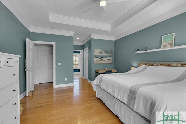 bedroom featuring ornamental molding, ceiling fan, light hardwood / wood-style floors, and a tray ceiling