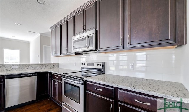 kitchen with tasteful backsplash, stainless steel appliances, crown molding, light stone countertops, and dark wood-type flooring