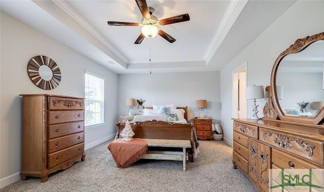 carpeted bedroom with a tray ceiling, ornamental molding, and ceiling fan