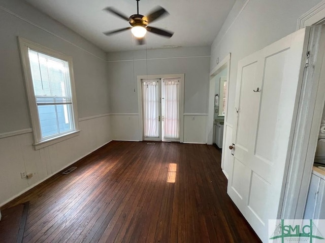 unfurnished room featuring plenty of natural light, dark hardwood / wood-style floors, and ceiling fan