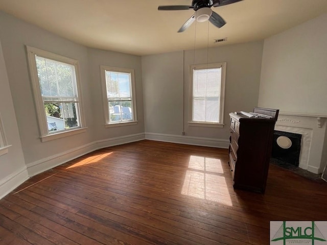 interior space with ceiling fan, dark hardwood / wood-style floors, and a fireplace