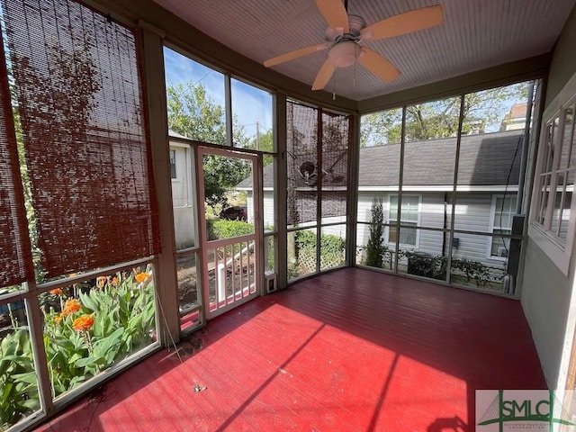 unfurnished sunroom with ceiling fan