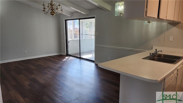 kitchen with sink, dark hardwood / wood-style floors, a notable chandelier, decorative light fixtures, and kitchen peninsula