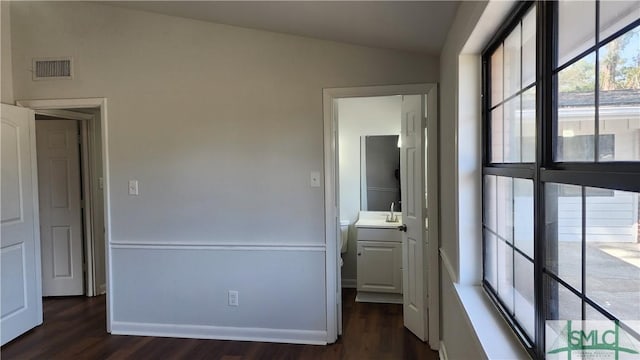 unfurnished bedroom with lofted ceiling, sink, connected bathroom, and dark hardwood / wood-style flooring