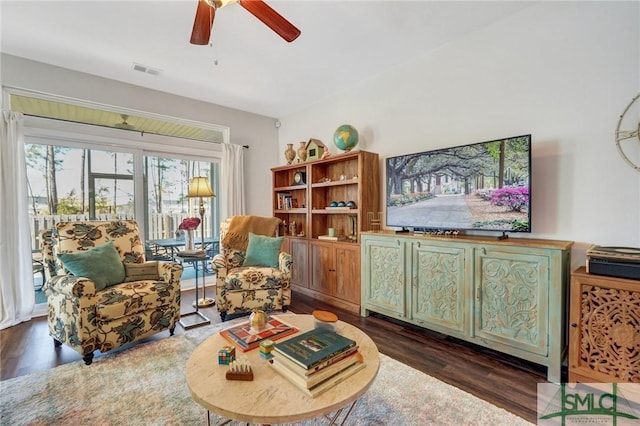 living room with dark hardwood / wood-style floors and ceiling fan