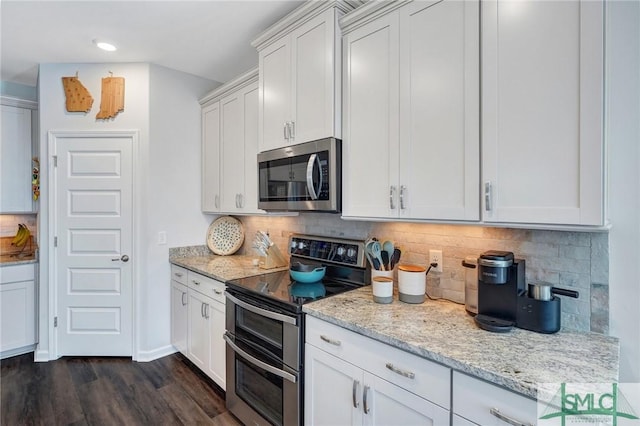 kitchen with stainless steel appliances, dark hardwood / wood-style floors, light stone countertops, and white cabinets